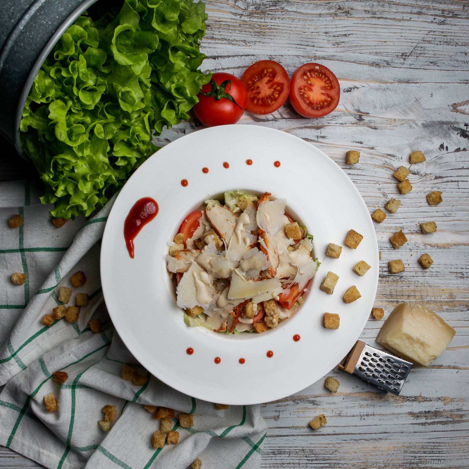 Top view caesar salad with crackers and cheese and lettuce in white plate on wood background